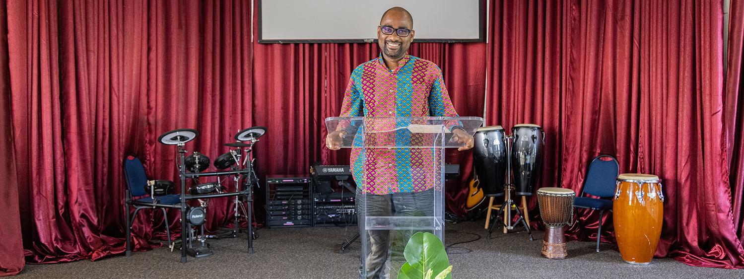 Francois Mikobi is standing at the lectern in church.