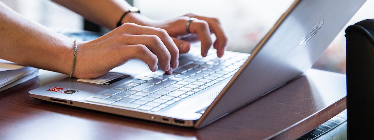 Student types on a laptop.