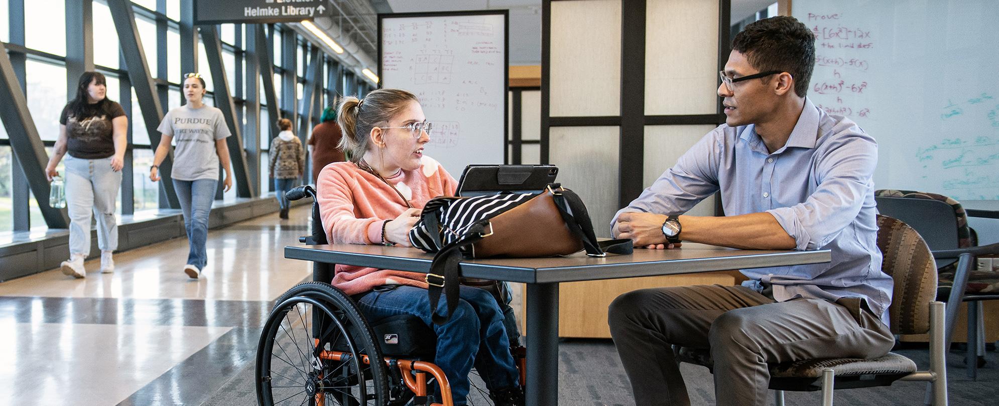 Students talk at a table in the Sky Bridge