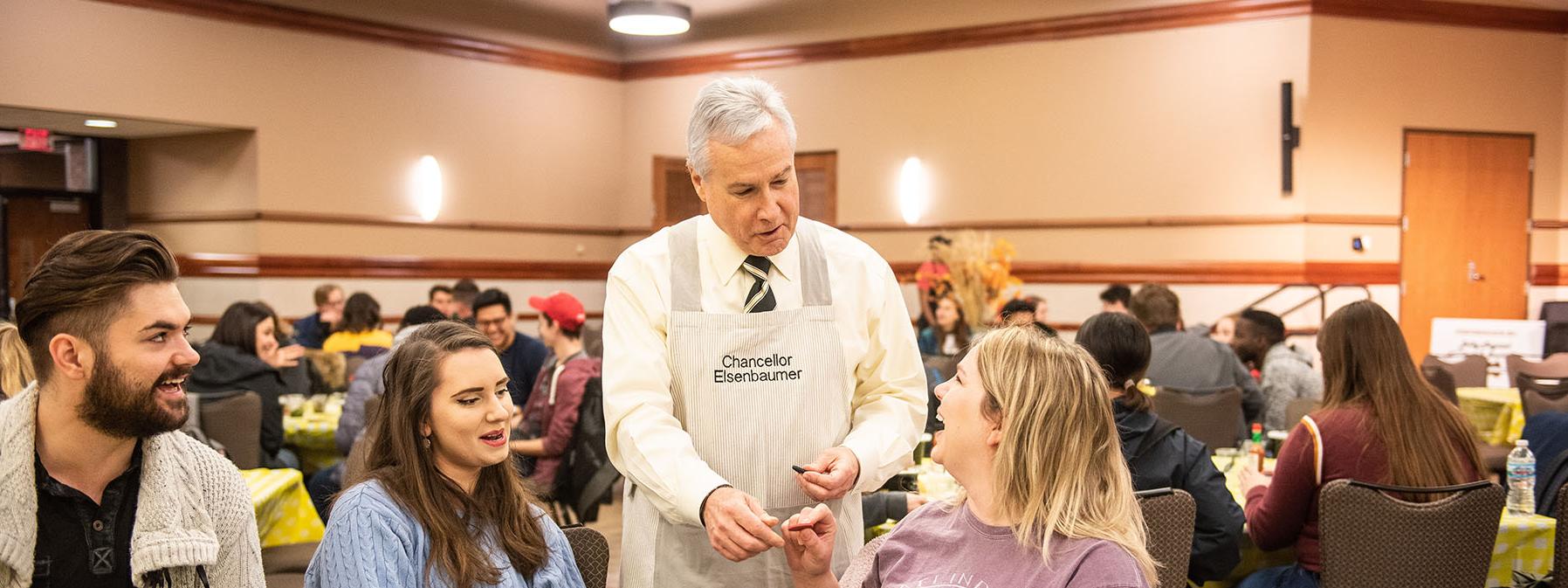 Chancellor Ron Elsenbaumer visits a table at Chili Fest.
