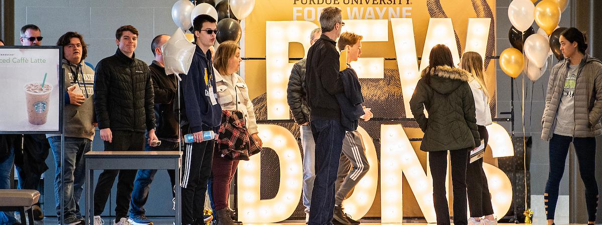 Visitors in front of the light up PFW DONS letters.