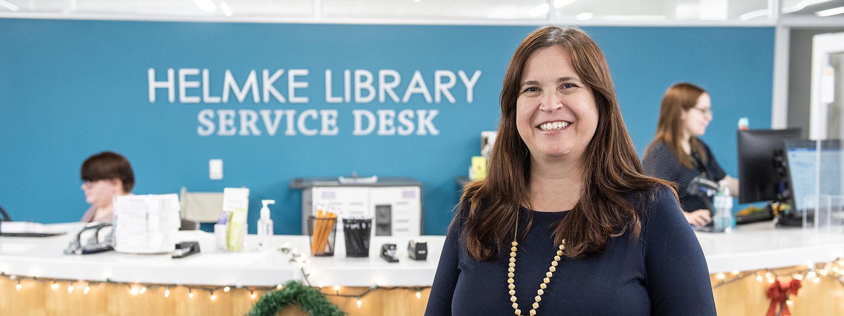 Erica Mann is in front of the Helmke Library information desk