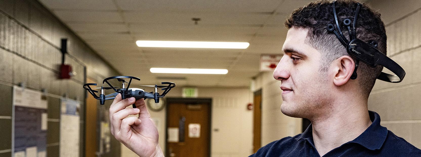 Abdelrahman Gad inspects a small, four-propeller drone.