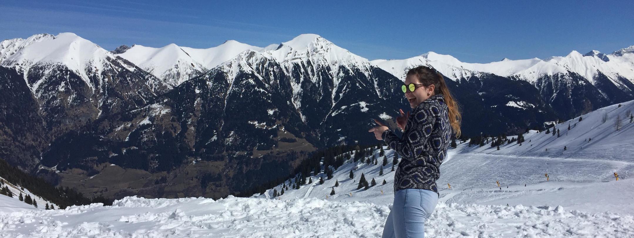 Student in the snow with mountain range in the background.