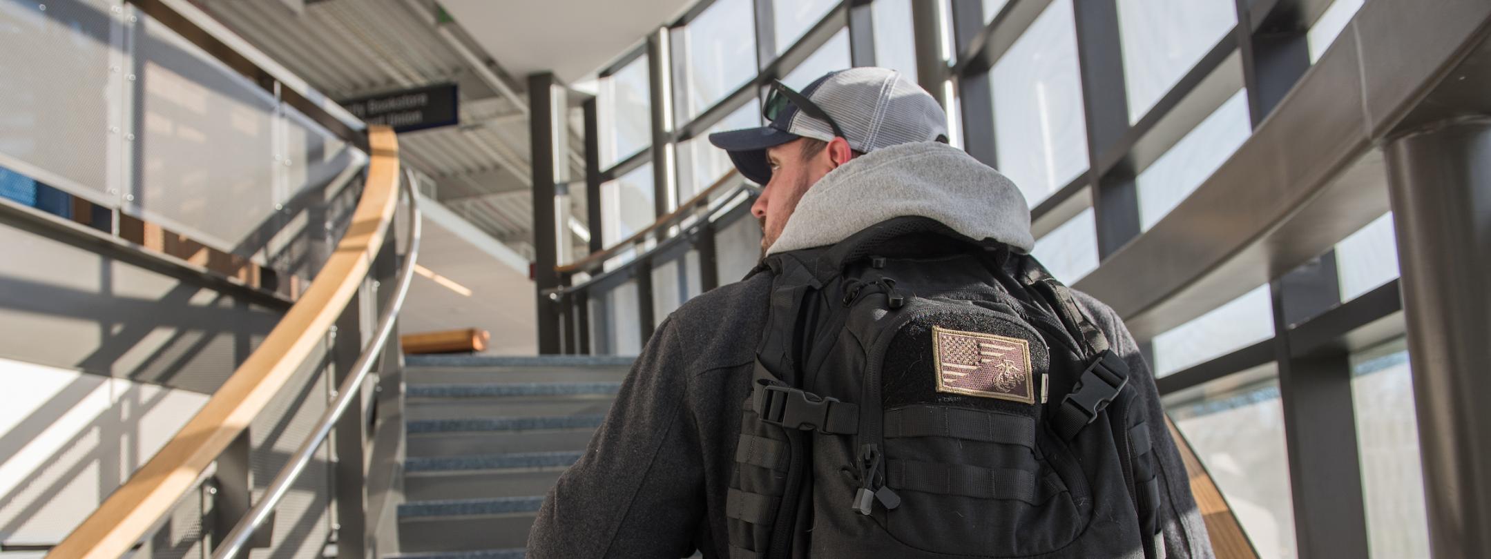 Veteran student walking up a staircase on campus.