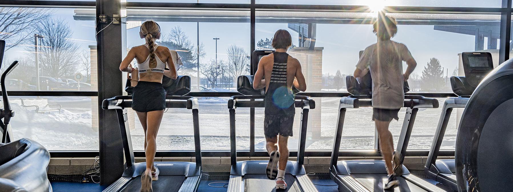 Three students running on treadmills