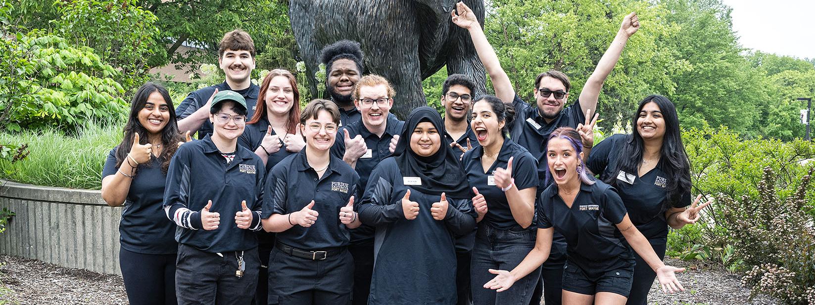 Student coaches in front of the mastodon statue