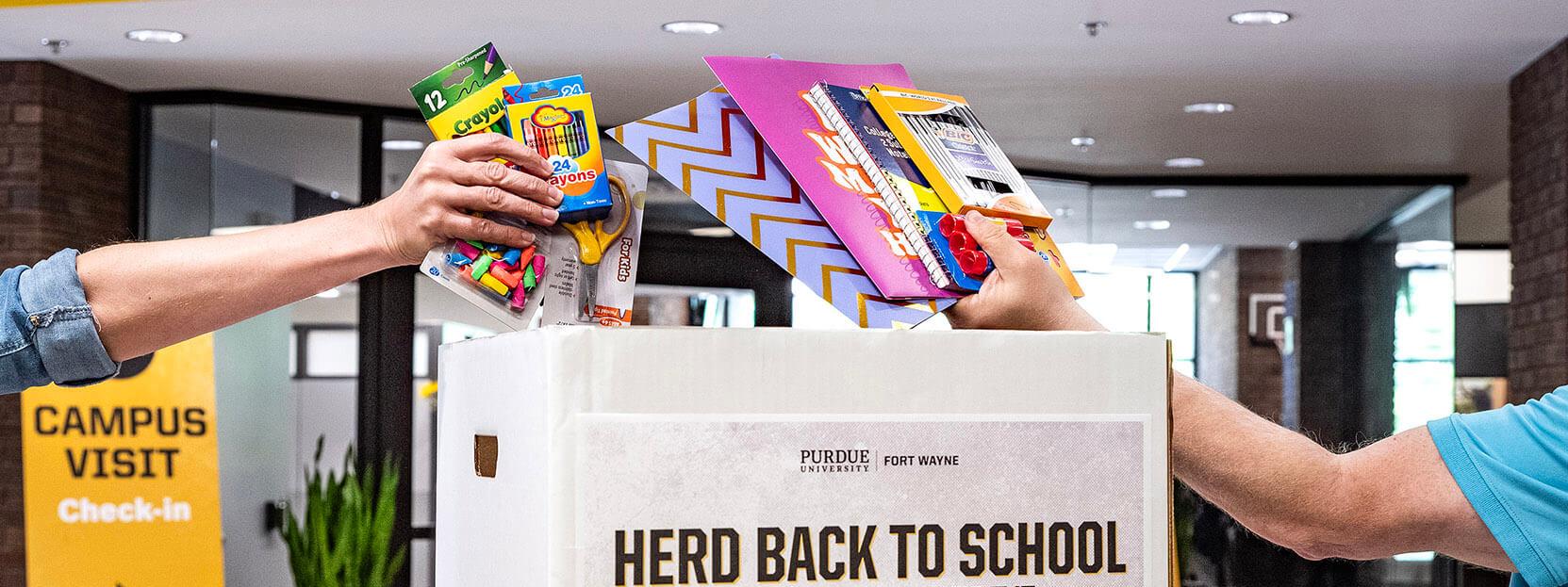 Placing school supplies in a drop box