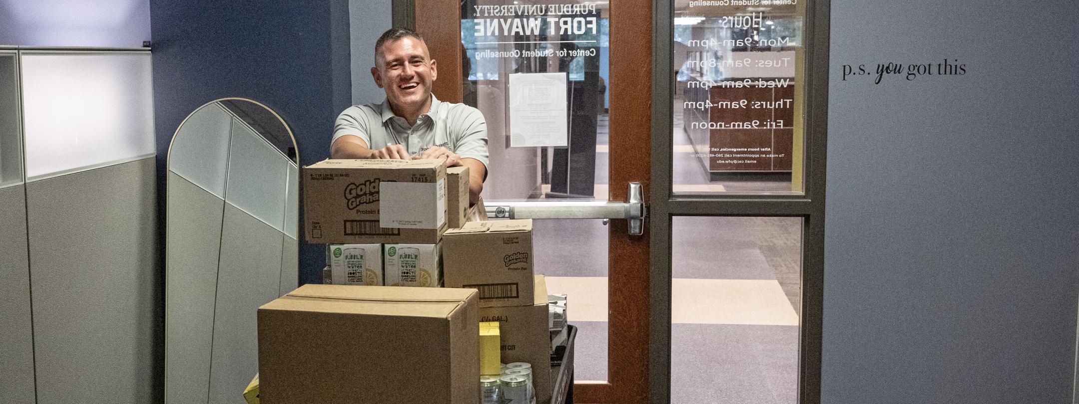 Eric Manor is moving items into the new pantry location in Kettler Hall