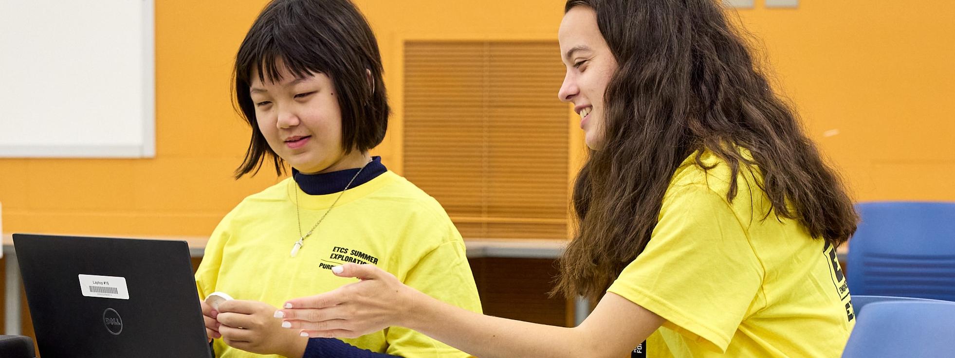 Student and Camp Lead working together on coding a drone