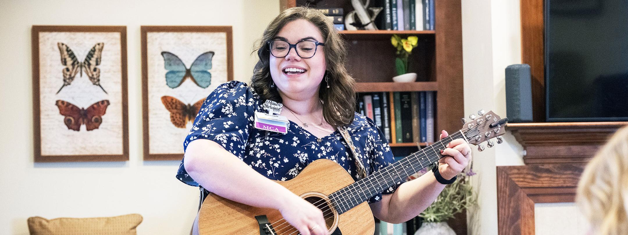 Brooke Sullivan is accompanying herself on the guitar while singing