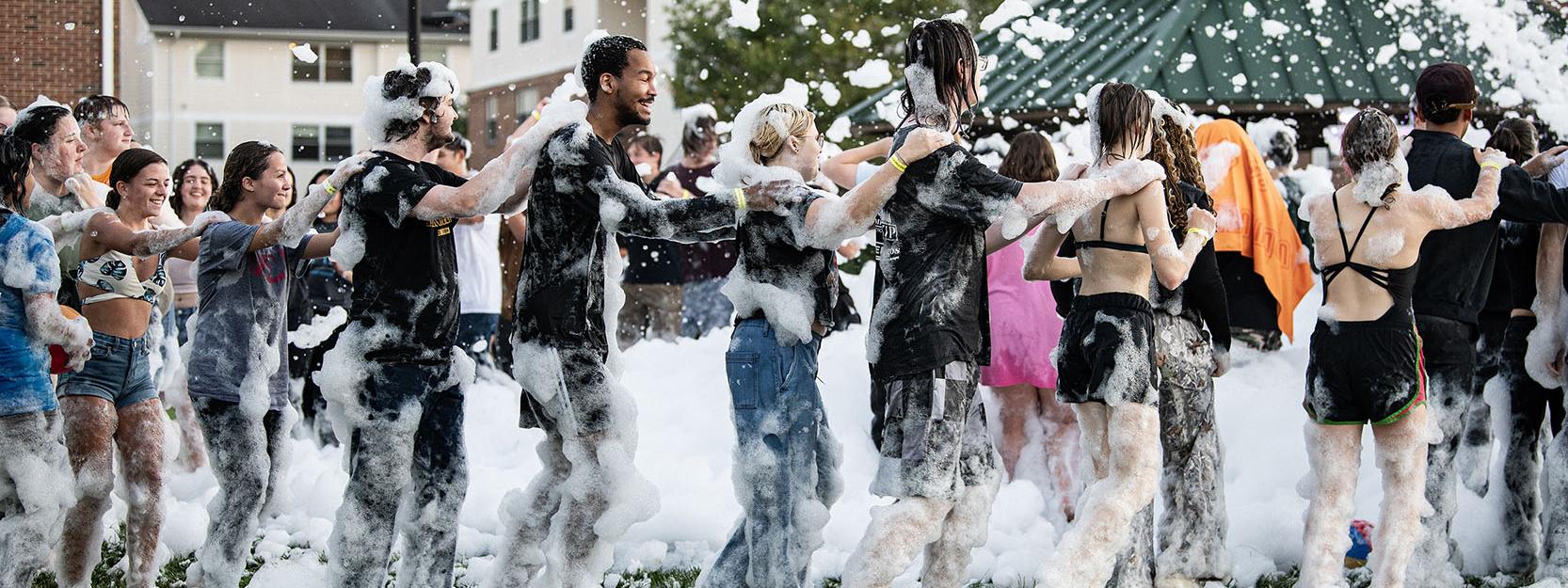 Students line dancing at the Foam Party at the Disco