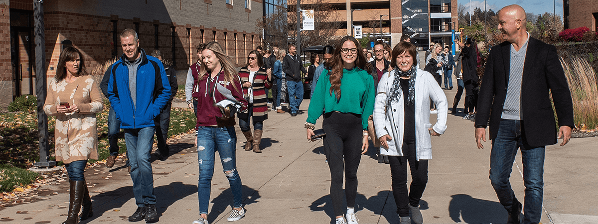 Students and their families are walking down the sidewalk