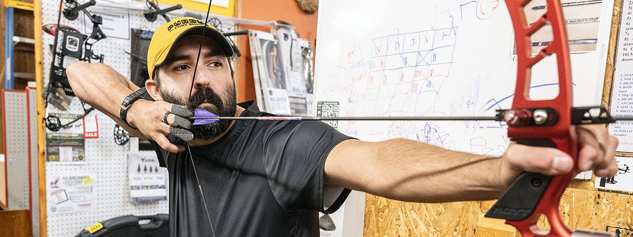 Cadd Amsler is drawing back an arrow