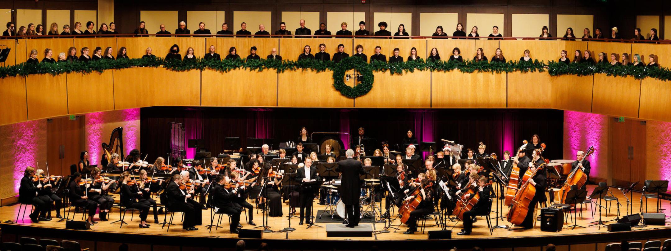 Choirs and an orchestra on stage at a holiday concert