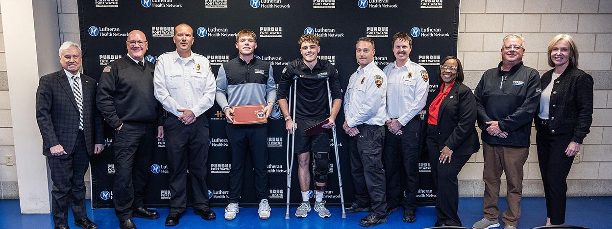 Several people are gathered for an award ceremony