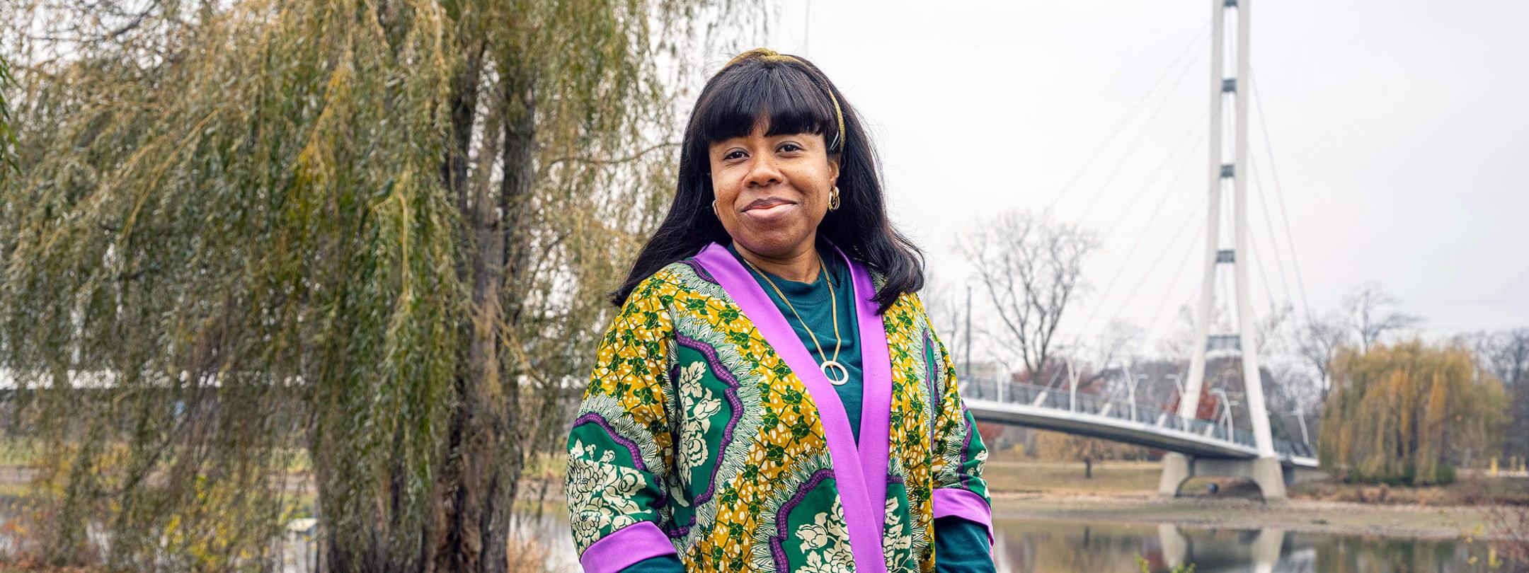 Stacy Abraham is on campus standing near a bridge