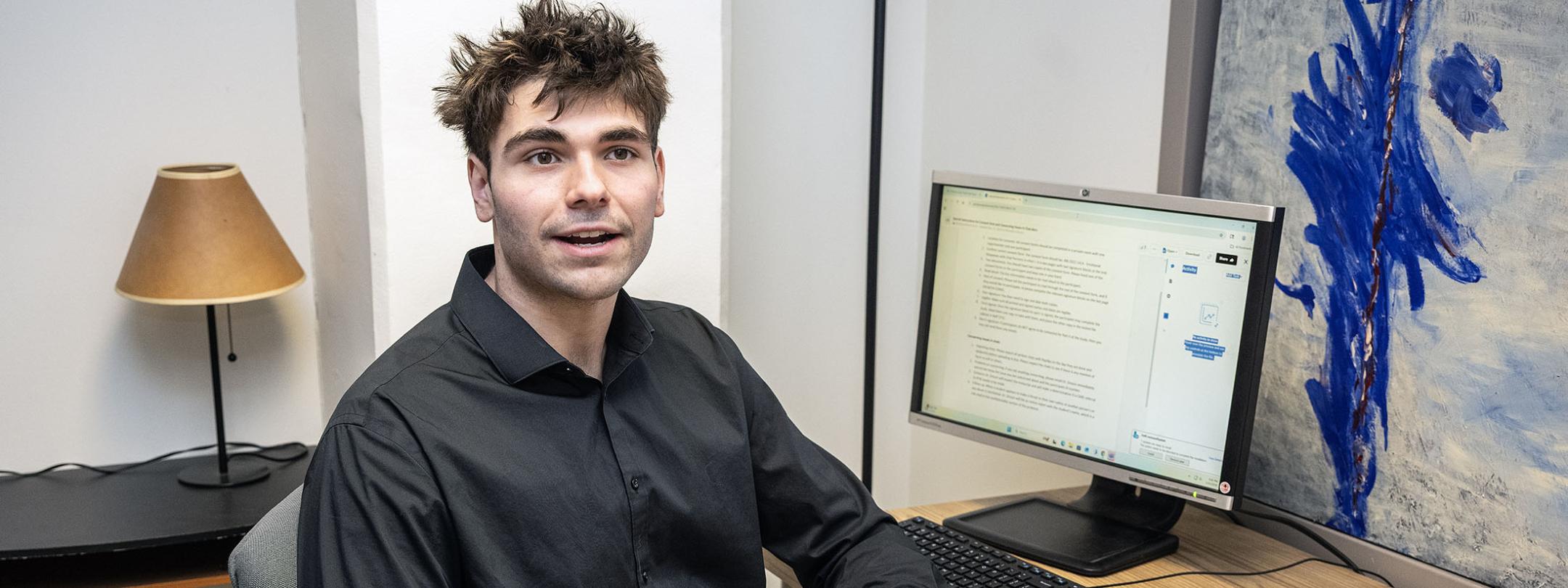 Hayden Crowell is sitting at a desk