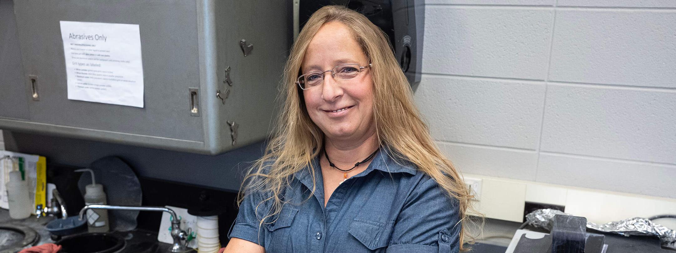 Jackie Miller is in a lab with her arms crossed