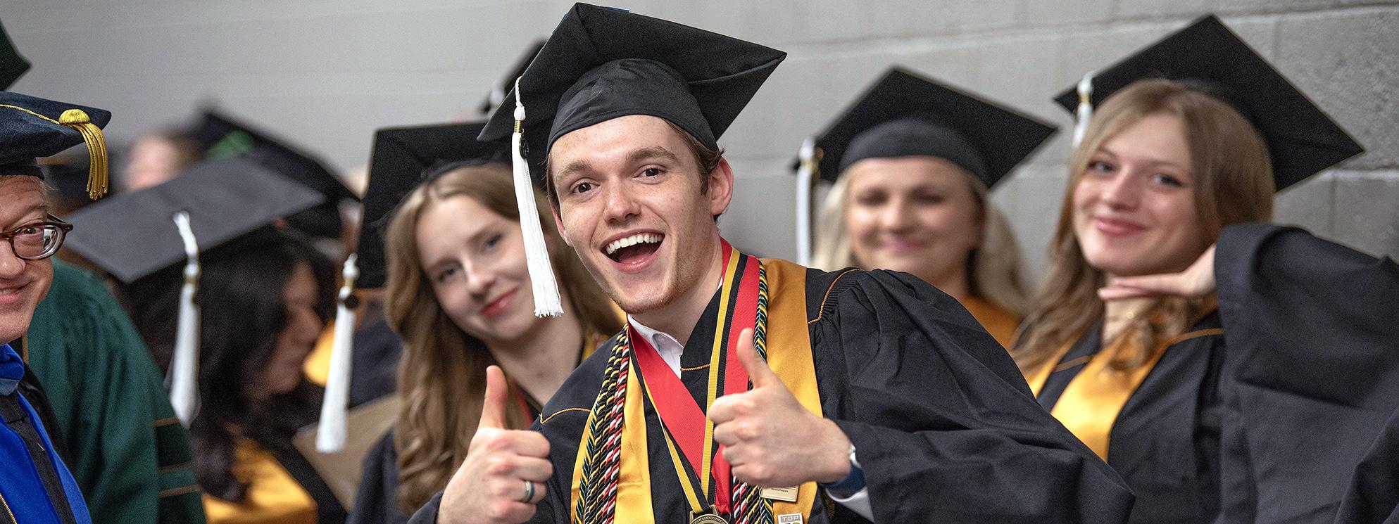 Graduating PFW student giving a thumbs up during commencement