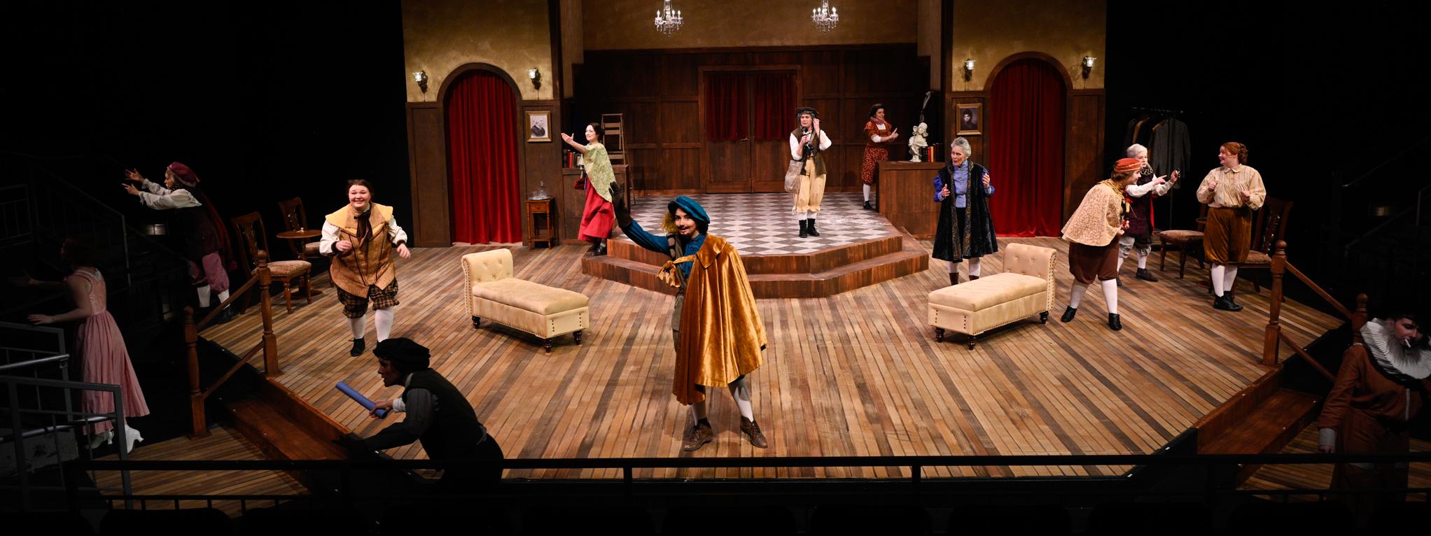 Wide shot of actresses on stage in shakespearean costumes in an early 1900s set