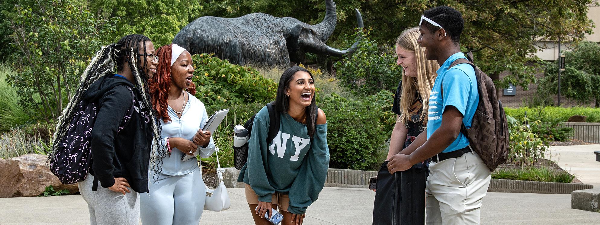 Students talking next to the bronze mastodon
