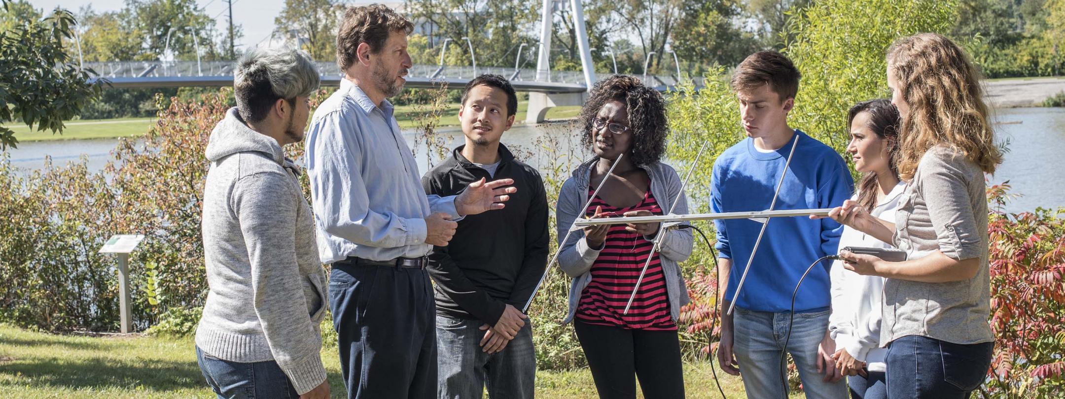 Biology professor explaining the use of an antenna in field research.
