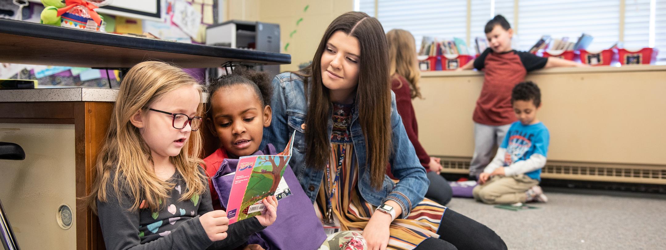 A student teacher reading with children