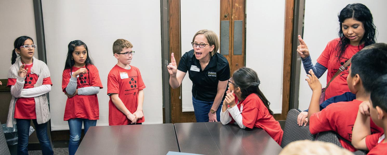 Professor Betz shows some signing skills to visiting elementary children