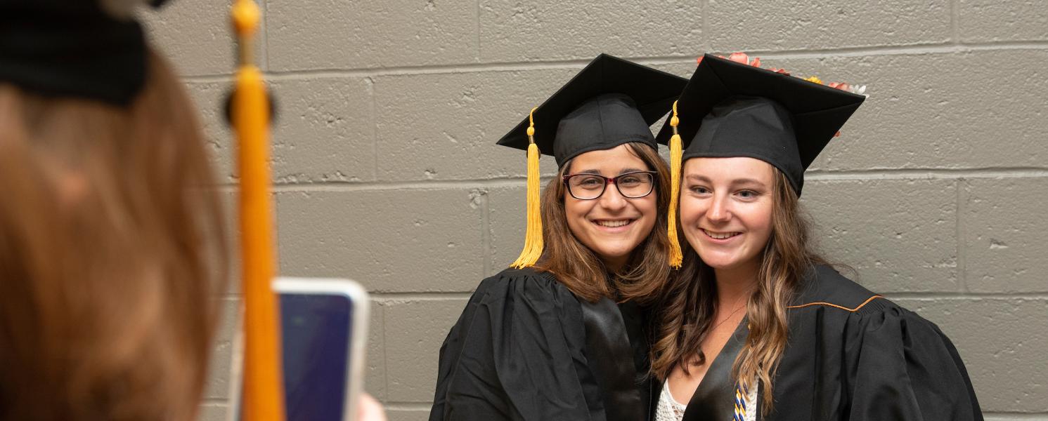 Graduating students pause for a photo back stage at commencement.