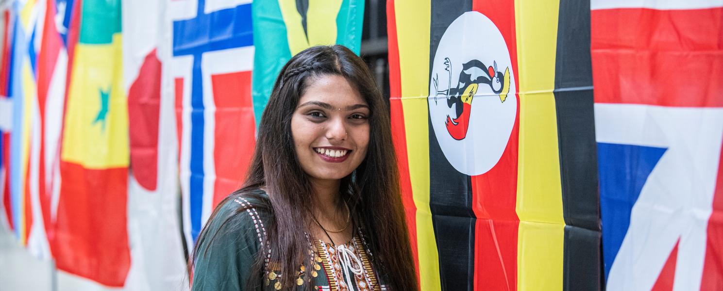Student in front of flags