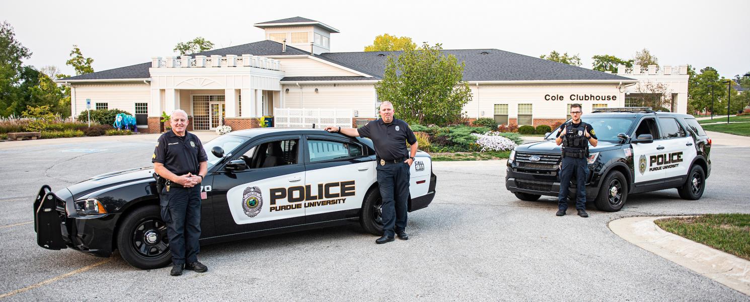 PFW university police stand near their cars.