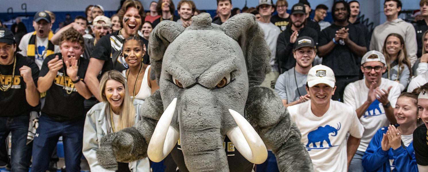 Student section and Don the Mastodon at a sporting event on campus.