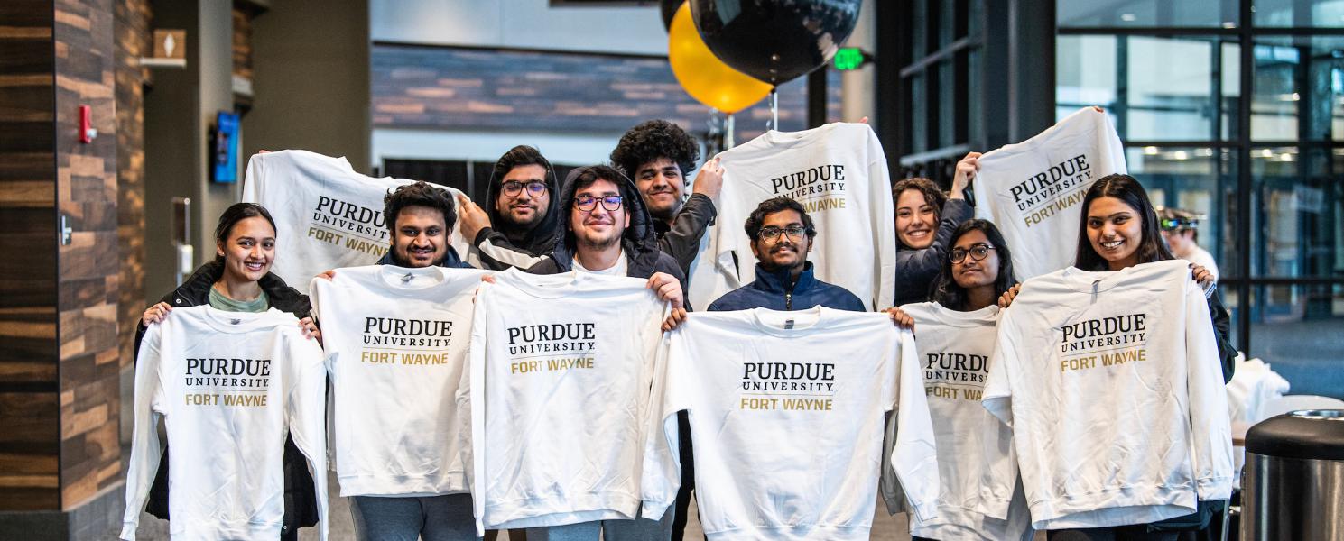 Students hold up PFW sweatshirts.