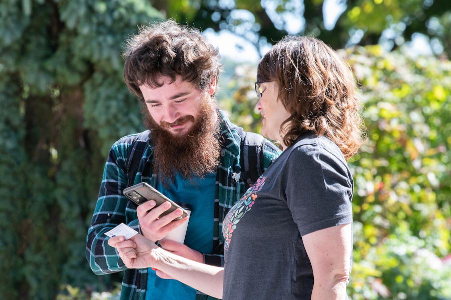 A student gets a phone number from a business card.