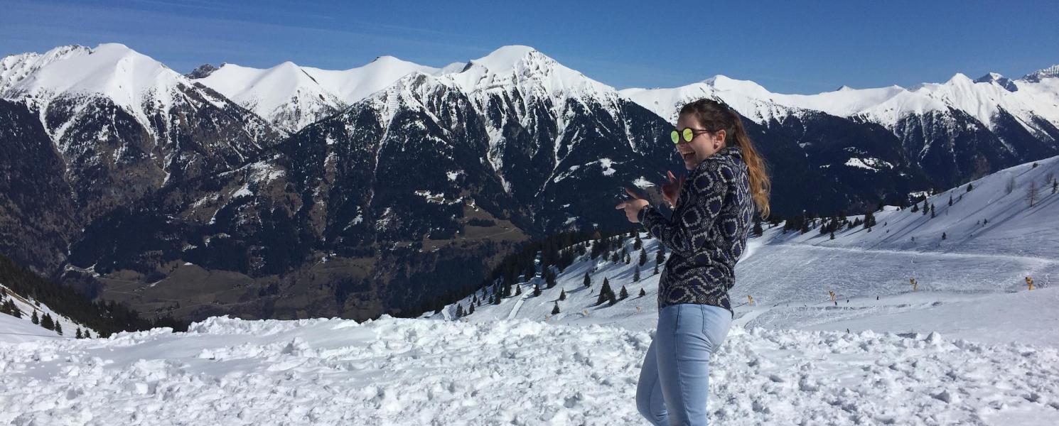 Student in the snow with mountain range in the background.