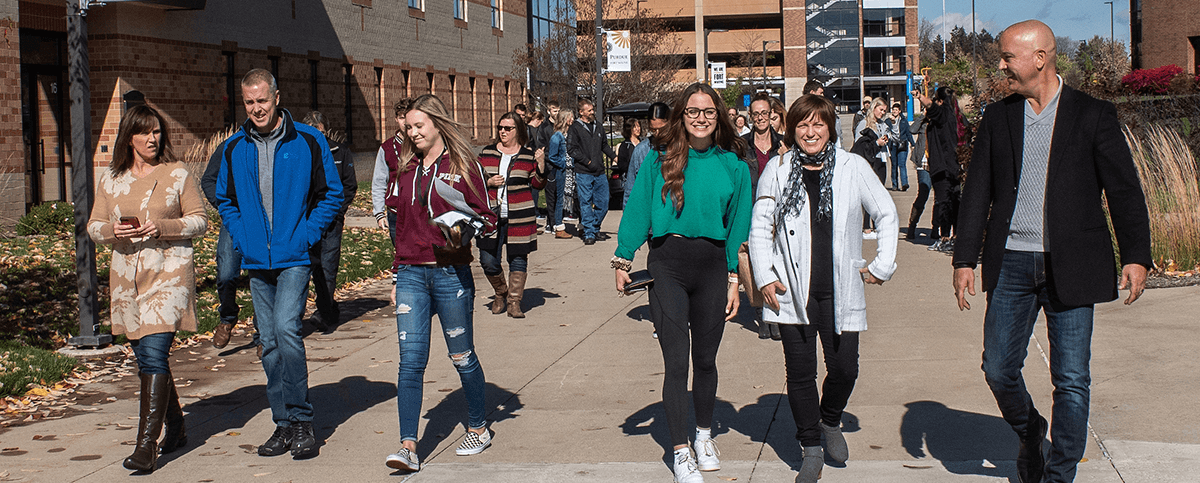 Students and their families are walking down the sidewalk