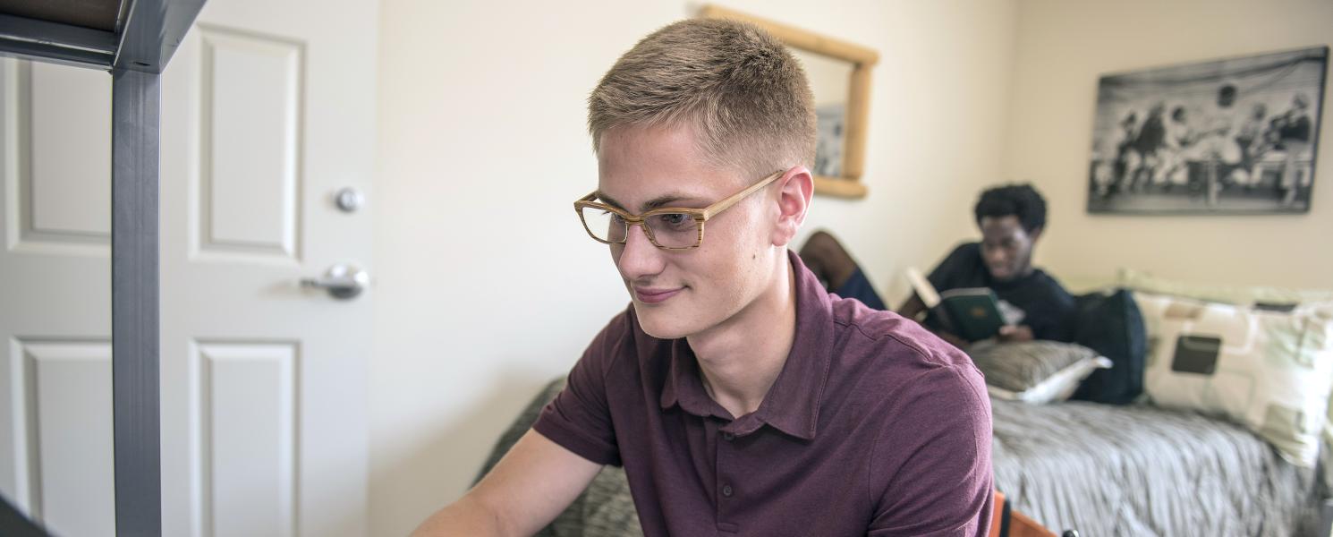 PFW students studying in their student housing bedroom.