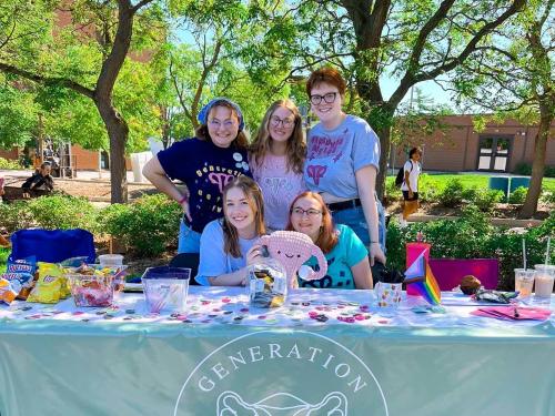 Five students standing behind a table at Campus Connections Fair