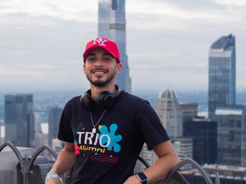 TRIO student poses with the city skyline in the background.