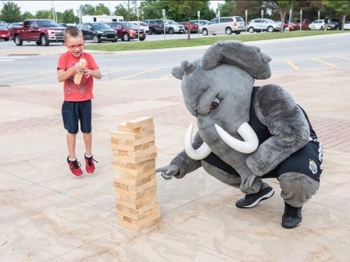 Mastodon playing game with kid
