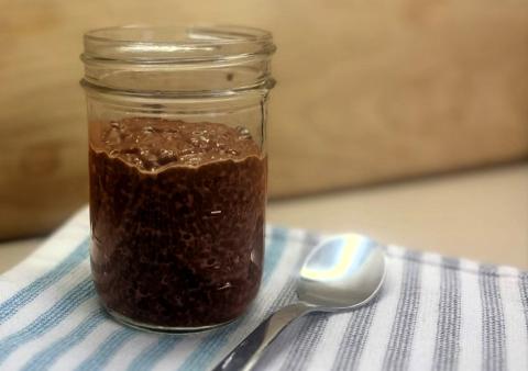 Chocolate chia pudding in a mason jar with spoon on a placemat for Meatless Mondays