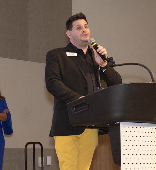 James Velez is speaking at a lectern