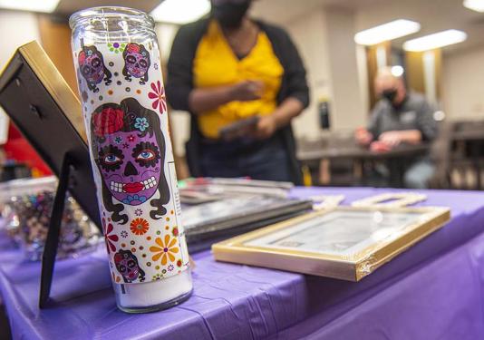 Day of the Dead altar display on a purple table in the student housing clubhouse.