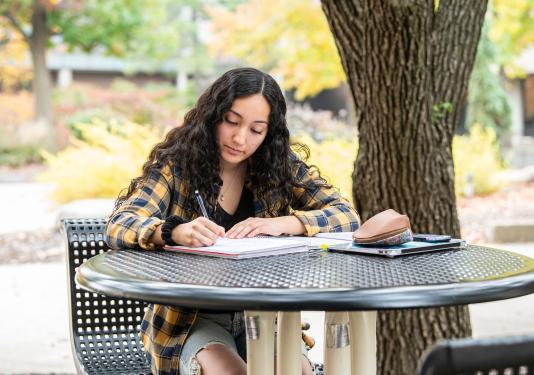 Student writing outdoors
