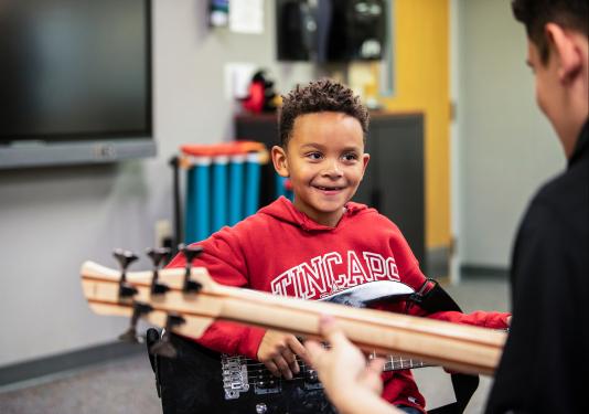 Child in music therapy inside Dolnick Hall.