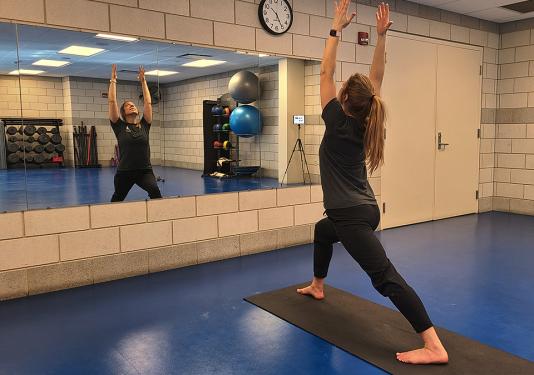 Instructor Lindsay Bloom demonstrating standing stretching exercise