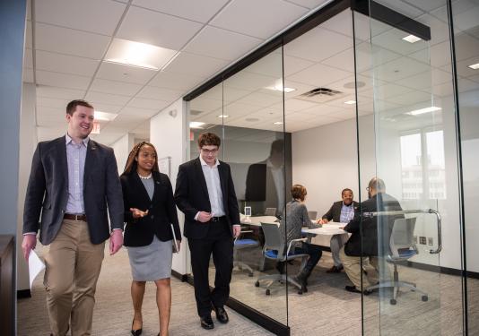 Business students walk down a hallway.