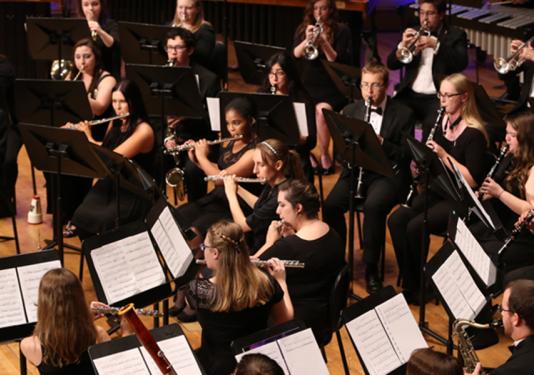 A group of students seated and playing instruments