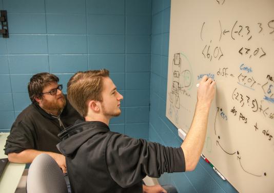 Students doing work on a whiteboard